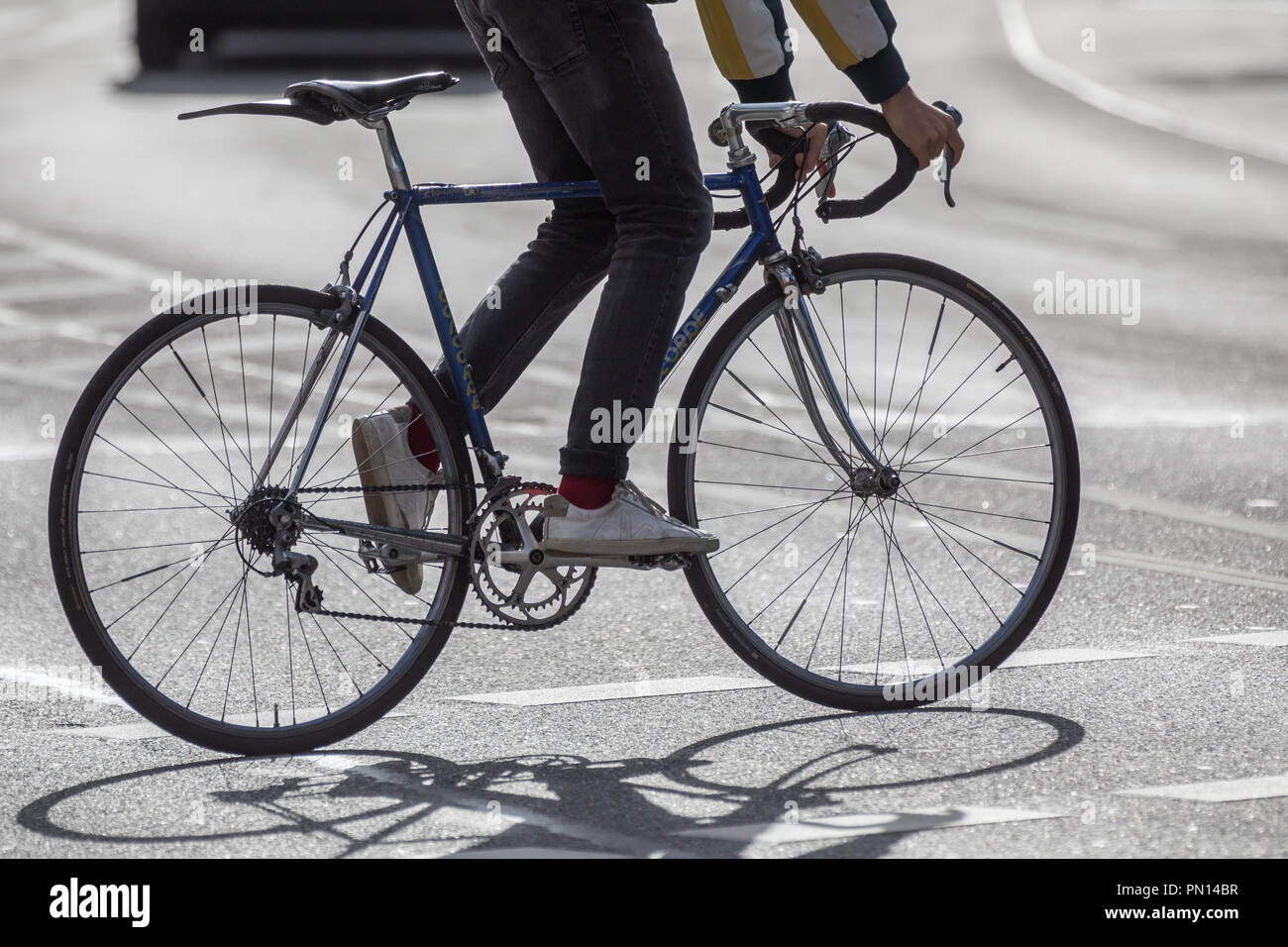 Cycliste sur route en rétro-éclairage Banque D'Images