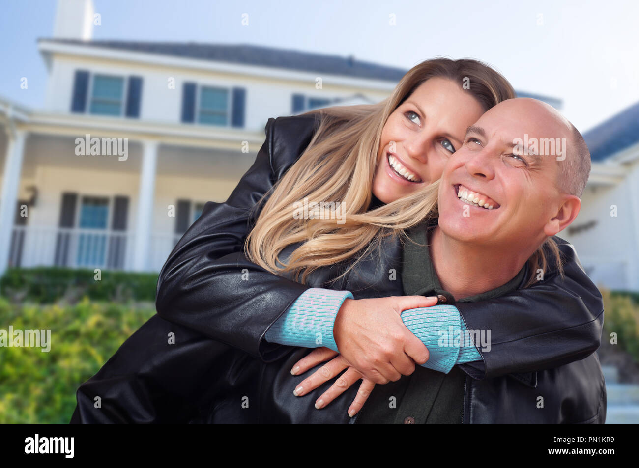 Heureux Couple Hugging in face de belle maison. Banque D'Images
