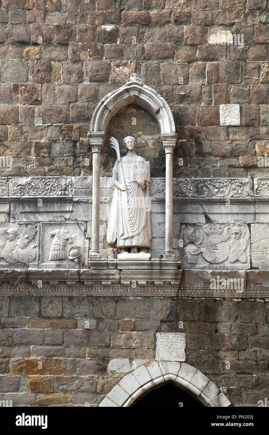 Statue (14ème siècle) de San Giusto décore l'entrée du clocher de la cathédrale de San Giusto à Trieste (Italie). Il est maintenant un Palm Banque D'Images