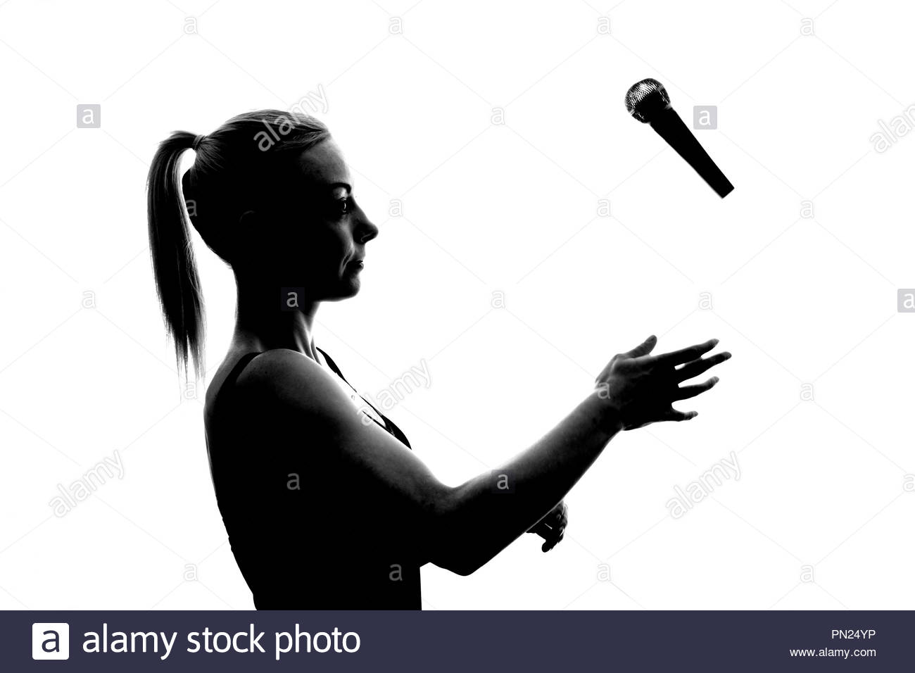 Femme avec queue de microphone jetant en l'air Banque D'Images Femme avec queue de microphone jetant en l'air Banque D'Images