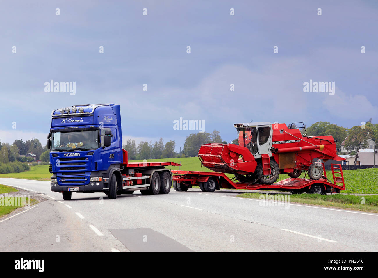 Scania R560 bleu semi-remorque de H. Tuomola commence le transport d'une moissonneuse-batteuse rouge un jour de début de l'automne. Salo, Finlande - septembre 2, 2018. Banque D'Images