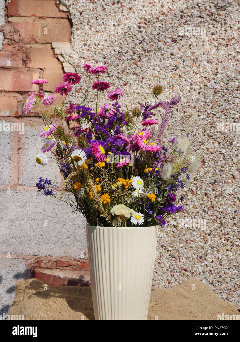 Bouquet de fleurs séchées dans un vase blanc Banque D'Images