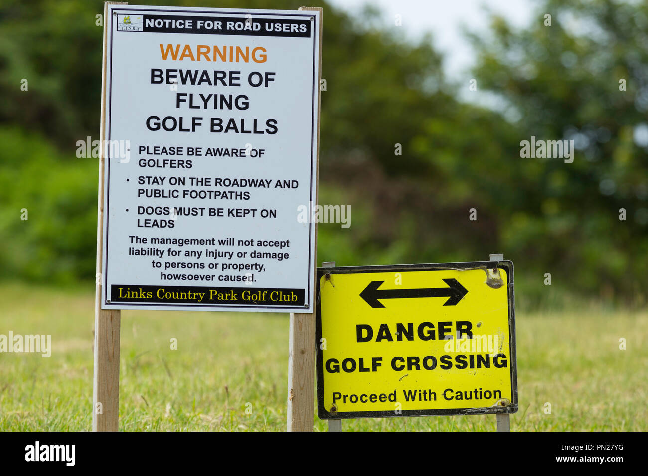 Signes d'avertissement lorsqu'une route traverse un terrain de golf. Banque D'Images