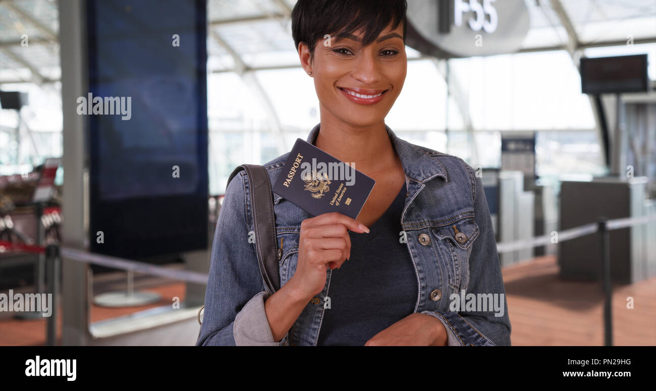 L'audacieuse femme africaine pose à l'aéroport avec passeport en toute confiance Banque D'Images