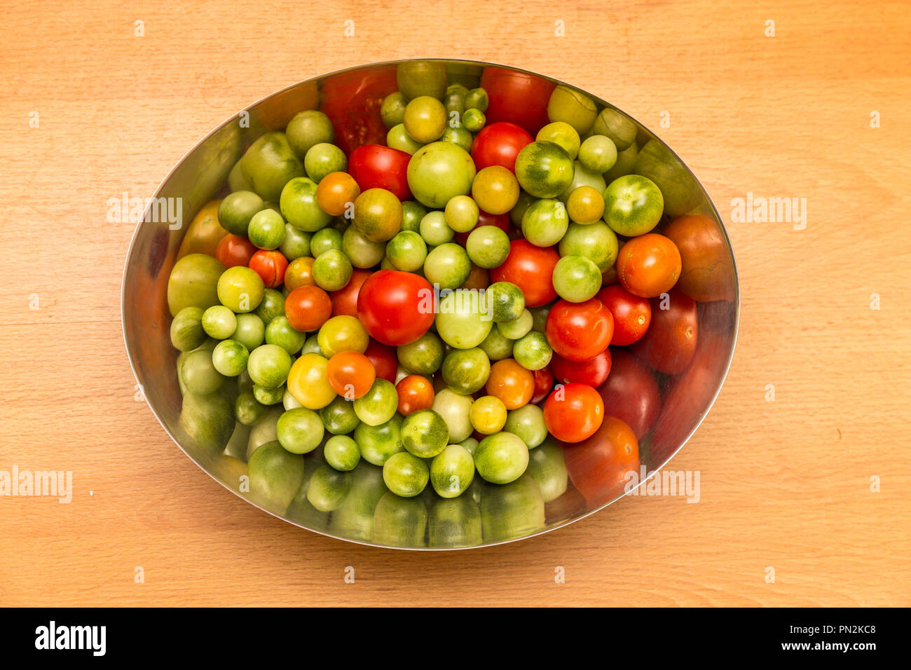 Fin de saison, les tomates mûres et fruit vert dans un bol. Banque D'Images