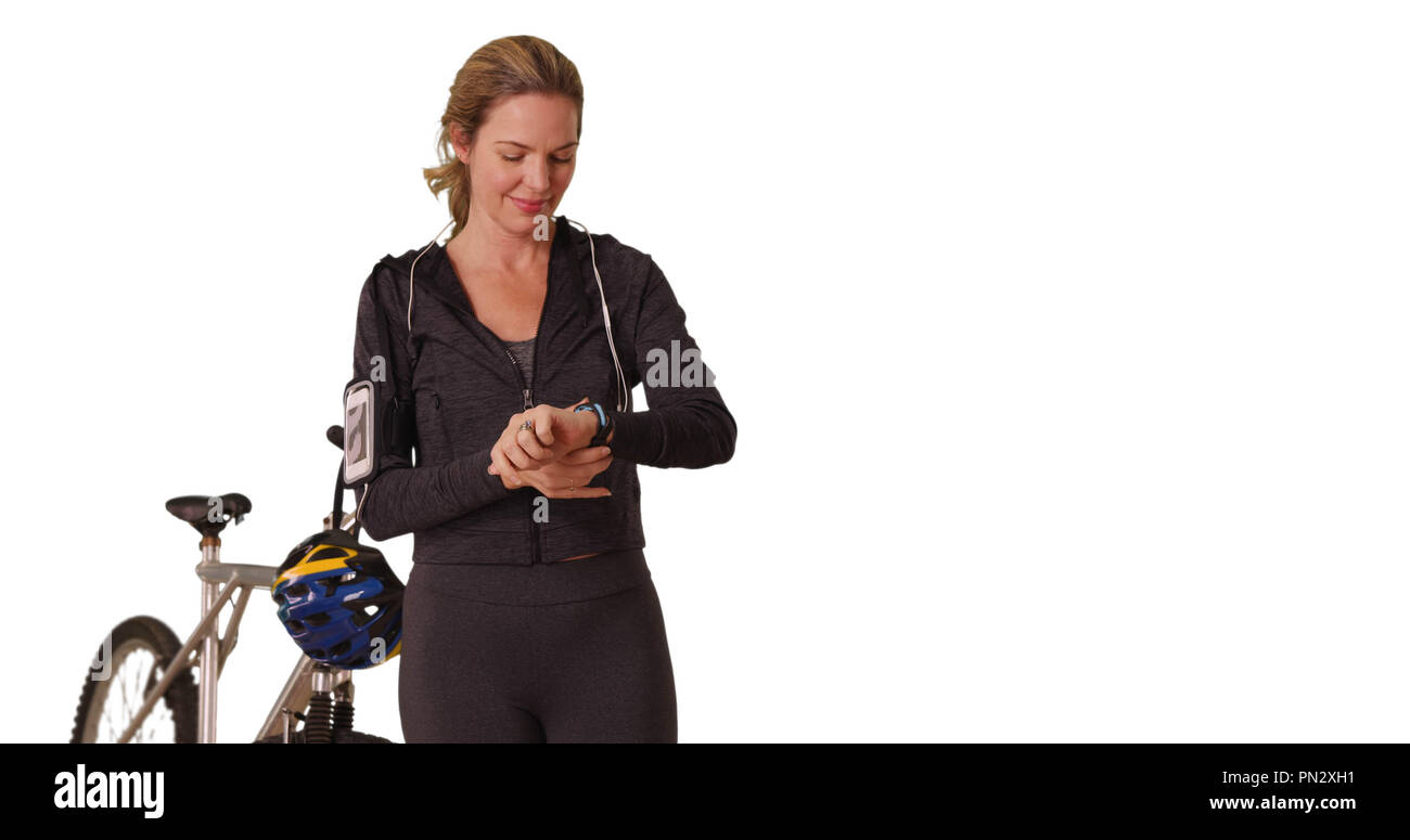 Middle aged woman vêtements de sport dans l'utilisation de device post entraînement Banque D'Images