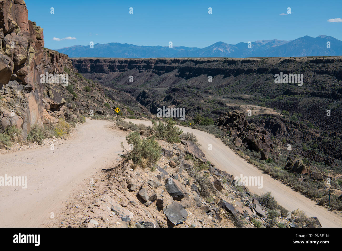 Route de terre dangereuses au bord du canyon du Rio Grande Gorge près de Taos, Nouveau Mexique avec la chaîne de montagnes Sangre de Cristo en arrière-plan Banque D'Images