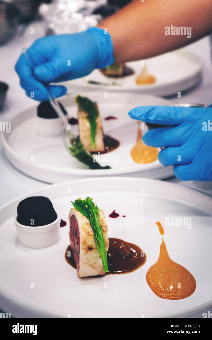 Chef, c'est la cuisson de la viande d'agneau steak avec de la moutarde, sauce aux baies rouge et charbon de pain dans cet hôtel ou un restaurant. cuisine décoration styliste alimentaire dîner temps f Banque D'Images