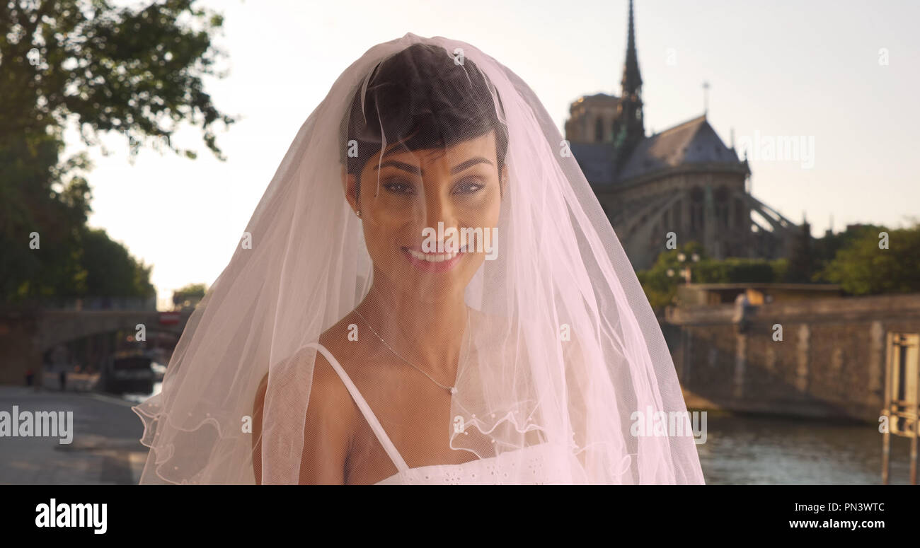 Mariée élégante rougissant à Paris France pose pour portrait par la Seine Banque D'Images