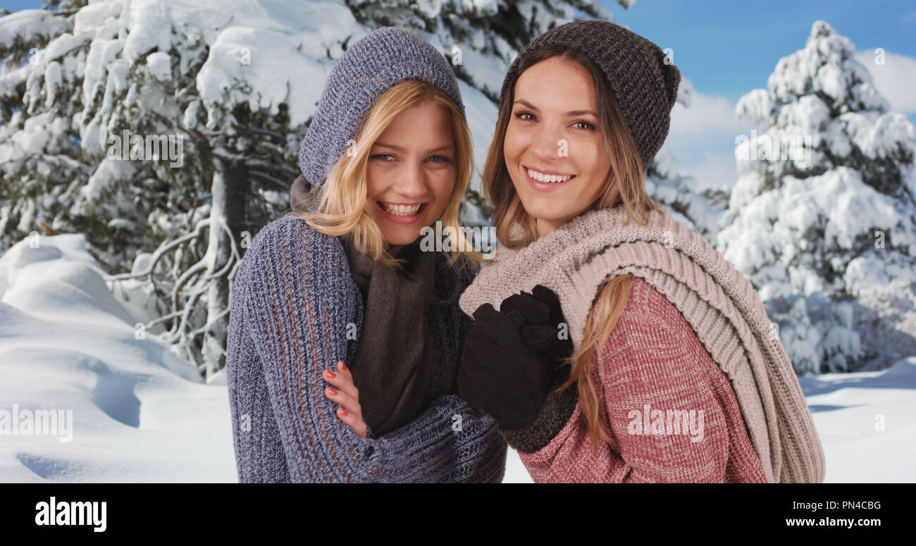 Cute Caucasian girls réchauffe avec bonnets et écharpes sur le paramètre dans la neige Banque D'Images