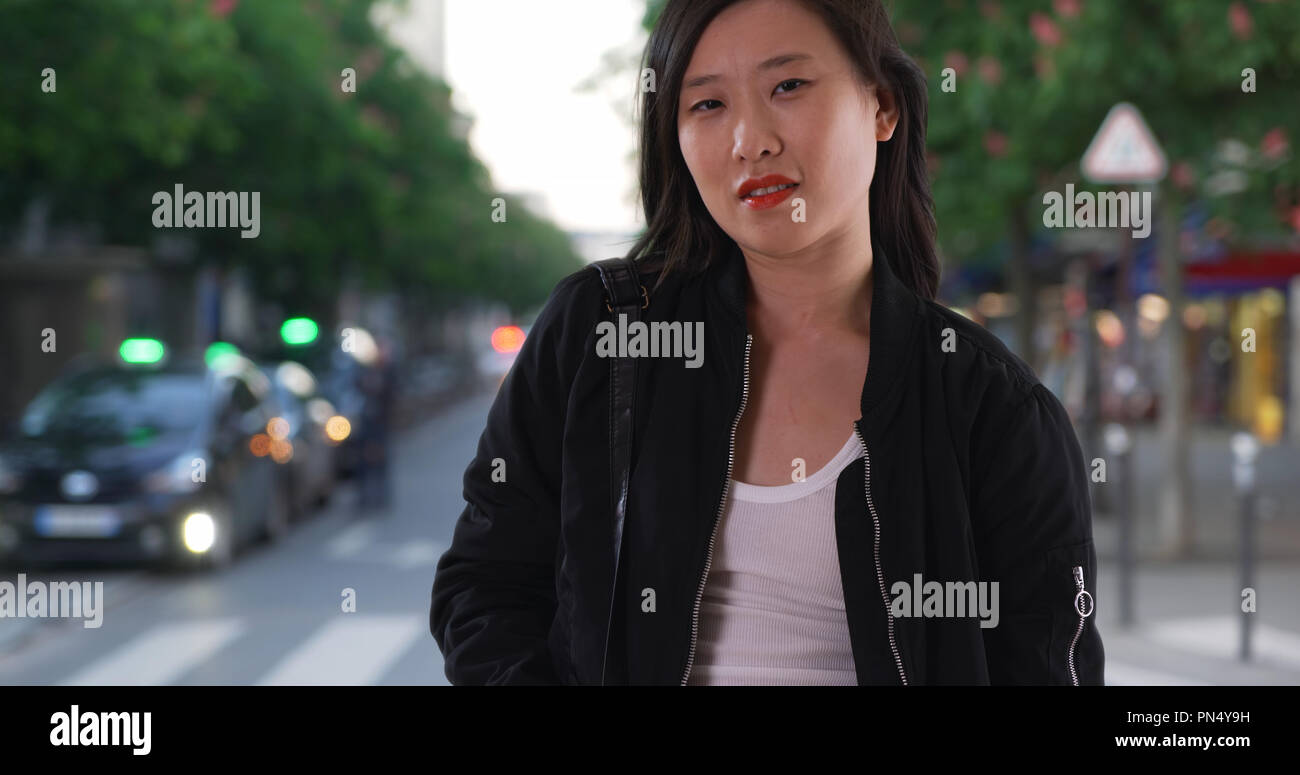 Chinese Woman in Black bomber jacket on city street avec les cheveux dans  le vent Photo Stock - Alamy