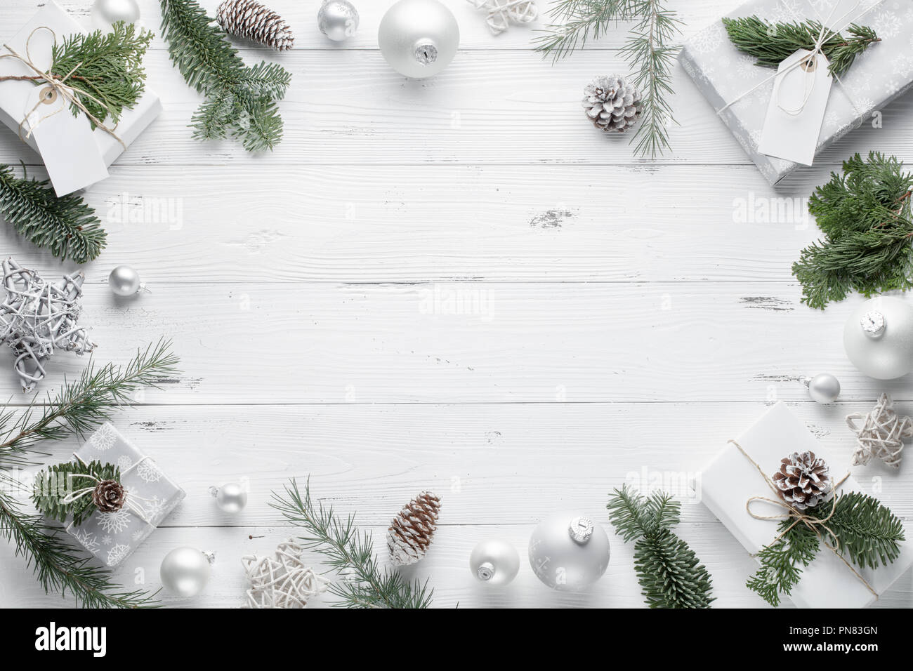 Cadeau de Noël, boules de Noël,couverture tricoté et branches de sapin sur fond blanc en bois. Mise à plat,vue d'en haut. Banque D'Images