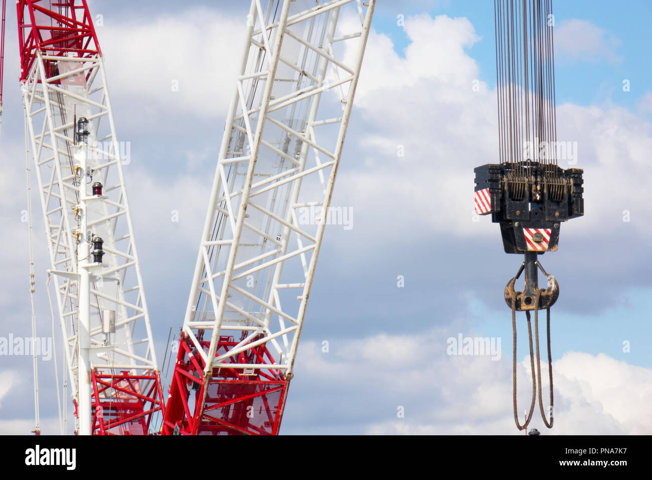 L'épandeur automatique d'une grue industrielle suspendu dans l'air avec fond de ciel bleu pourrait Banque D'Images