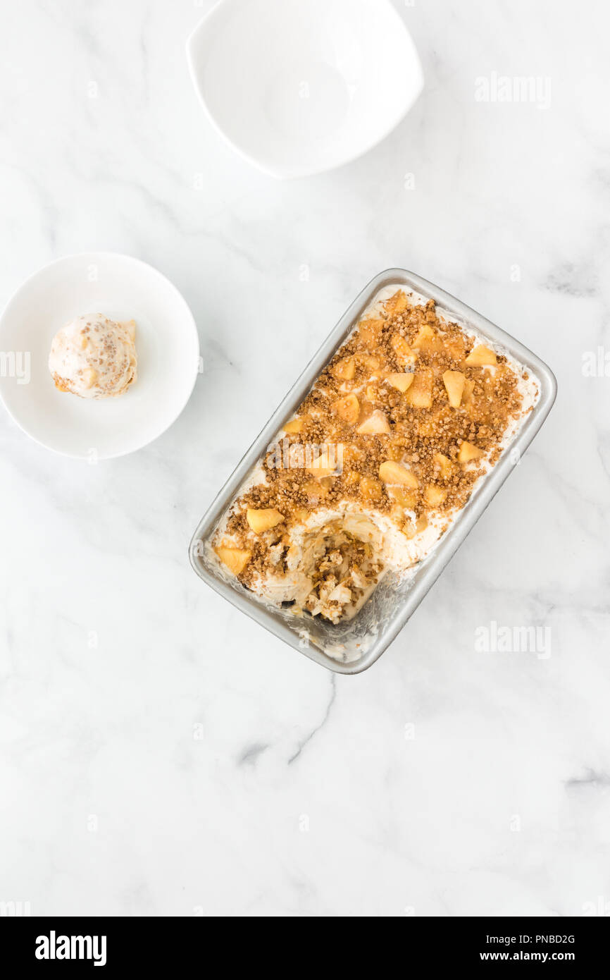 Le caramel maison glace aux pommes, glace vanille, sauce caramel, pommes et cannelle charlottes en récipient en métal et bol. Banque D'Images