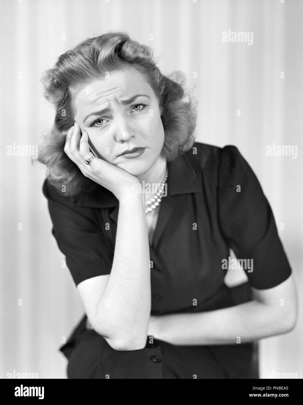 1940 WOMAN LOOKING AT CAMERA AVEC UNE triste maladie douloureuse mécontents de l'expression faciale - UN2730 HAR001 PERSONNES HARS Mal de tête B&W EXPRESSIONS DE TRISTESSE DANS LES YEUX DE LA DÉCOUVERTE DE LA SOUFFRANCE BRUNETTE DÉGOÛT mal de dents MAL DE MAUVAISE SANTÉ DÉÇU EN DIFFICULTÉ À MI-MÉCONTENT DES PROFILS MID-ADULT WOMAN MISÉRABLE ACHE NOIR ET BLANC PORTRAIT DE L'ORIGINE ETHNIQUE N'AIMENT PAS HAR001 old fashioned Banque D'Images