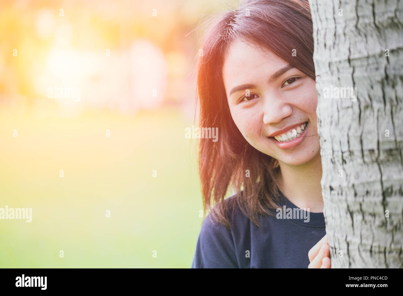 Asian teen mignon sain sourire dans le parc de l'espace pour le texte. Banque D'Images