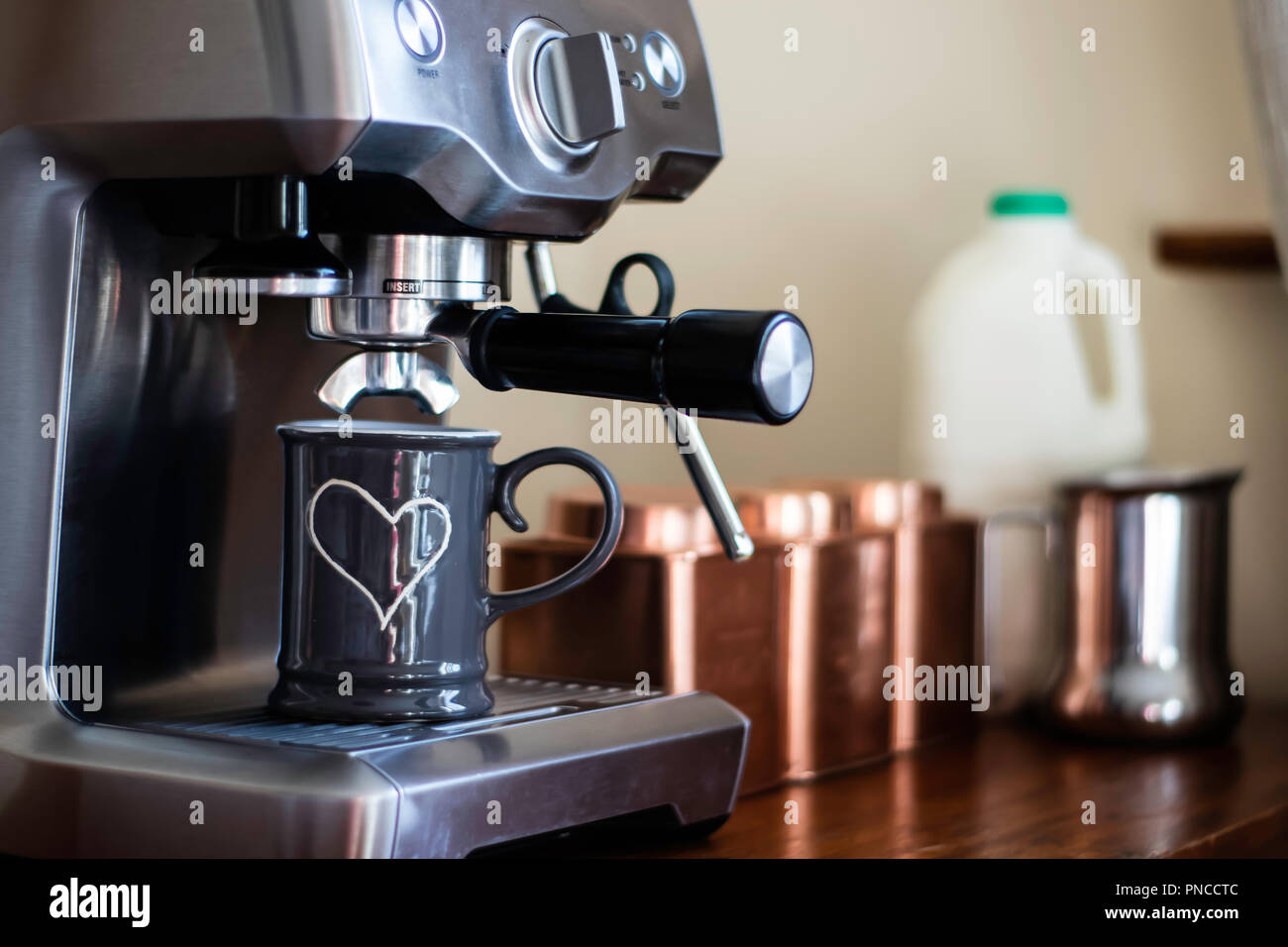 Coupe Grey avec détail coeur blanc en vertu d'une machine à expresso en acier inoxydable. Banque D'Images