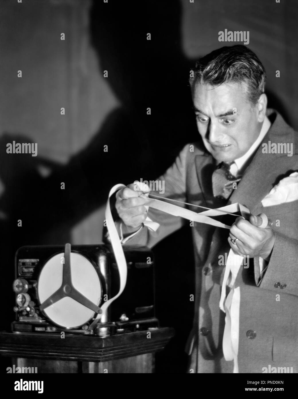 1920 ANONYME PANIQUÉ BUSINESSMAN LOOKING AT STOCK TICKER TAPE NOIRE LE MARDI 29 OCTOBRE 1929 - Bx00331 CAM001 HARS GRAND CRASH PANIQUE COPIE ESPACE VERTICAL PERSONNES demi-longueur d'AVION MÂLES PEUR RISQUE TICKER BANKER middle-aged B&W TRISTESSE FINANCIERS middle-aged MAN costume et cravate étrange CATASTROPHE DÉCOUVERTE COURTIER EXCITATION CAM001 CINGLÉS DE MAUVAISES NOUVELLES PROFESSIONS NON TRADITIONNELLES IDIOSYNCRASIQUE ÉCONOMIQUE INVESTISSEUR ANONYME PANIQUÉ EXCENTRIQUE AMUSANT RUINE MISÉRABLE STOCK TRADER BOURSE 1929 de l'origine ethnique caucasienne EN NOIR ET BLANC à l'ancienne économie irrégulière Banque D'Images