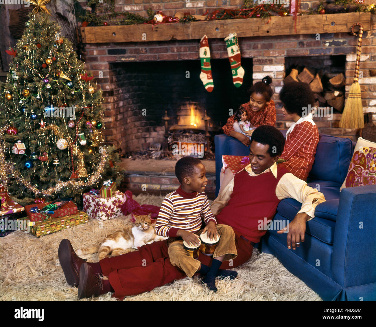 1970 AFRICAN AMERICAN FAMILY ENSEMBLE PAR L'ARBRE DE NOËL ET cheminée canapé du salon - kx7593 PHT001 HARS DOLL MARI CHEMINÉE Papa maman quatre à l'intérieur du vêtement pour homme paire nostalgique 4 BAS DE NOËL DE BANLIEUE MÈRES COULEUR VIEUX TEMPS NOSTALGIE FRÈRE SOEUR 1 OLD FASHION STYLE TABLE JUVÉNILE EVE FILS HEUREUX FAMILLE JOIE CÉLÉBRATION DE VIE FEMMES FRÈRES MARIÉS MARI CONJOINT ACCUEIL VIE pleine-longueur Filles Garçons FRÈRES SOEURS VEST PÈRES BONHEUR FORCE JOYEUSE SALON africains-américains africains-américains et les papas EXCITATION NOIR ORIGINE PAR SŒUR SOURIRE DÉCEMBRE Banque D'Images