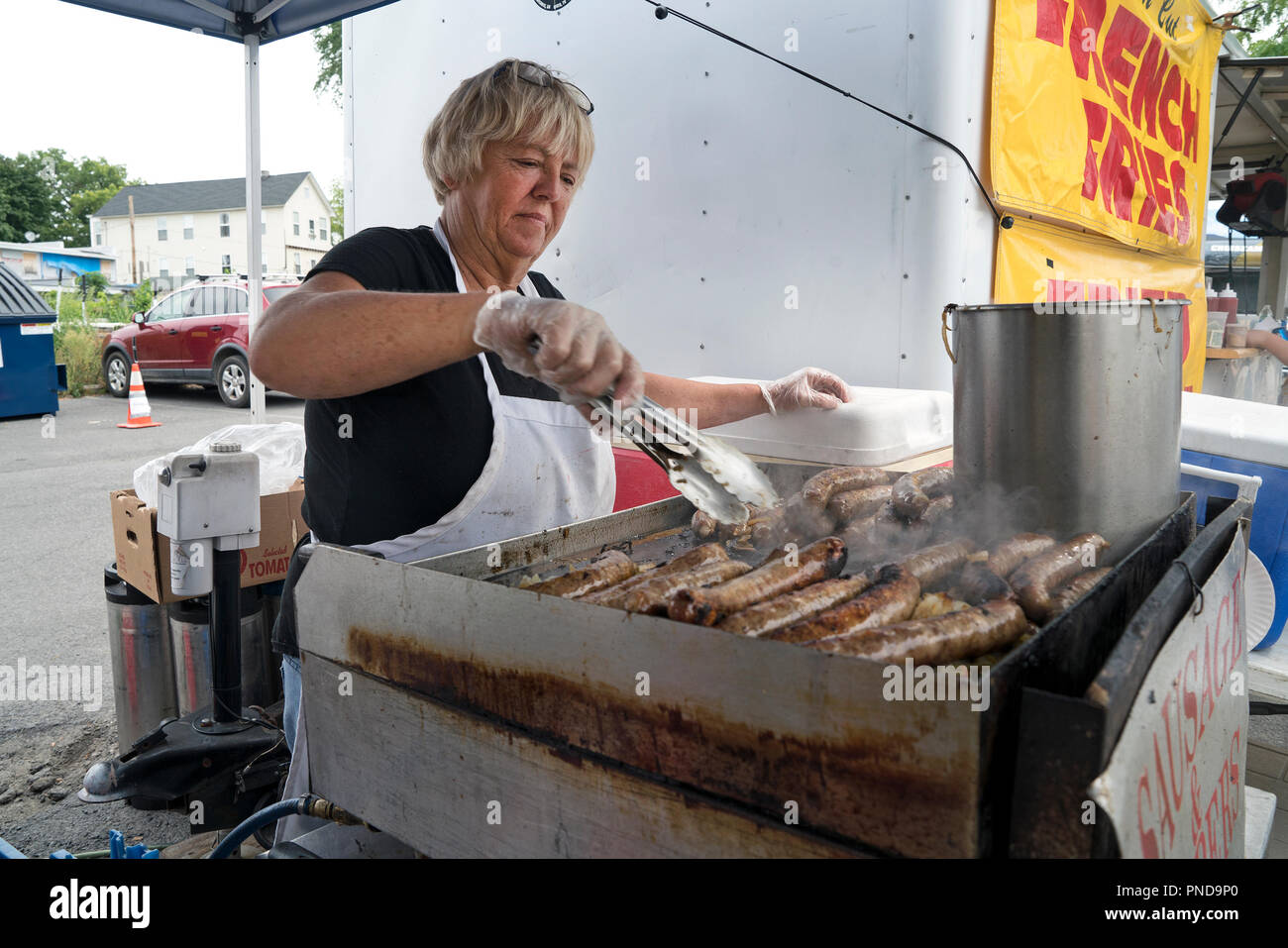 Une femme sur le gril saucisses et poivrons à l'assemblée annuelle de Roundup remorqueur Waterford, New York, un village à l'extrémité est du canal Érié. Banque D'Images
