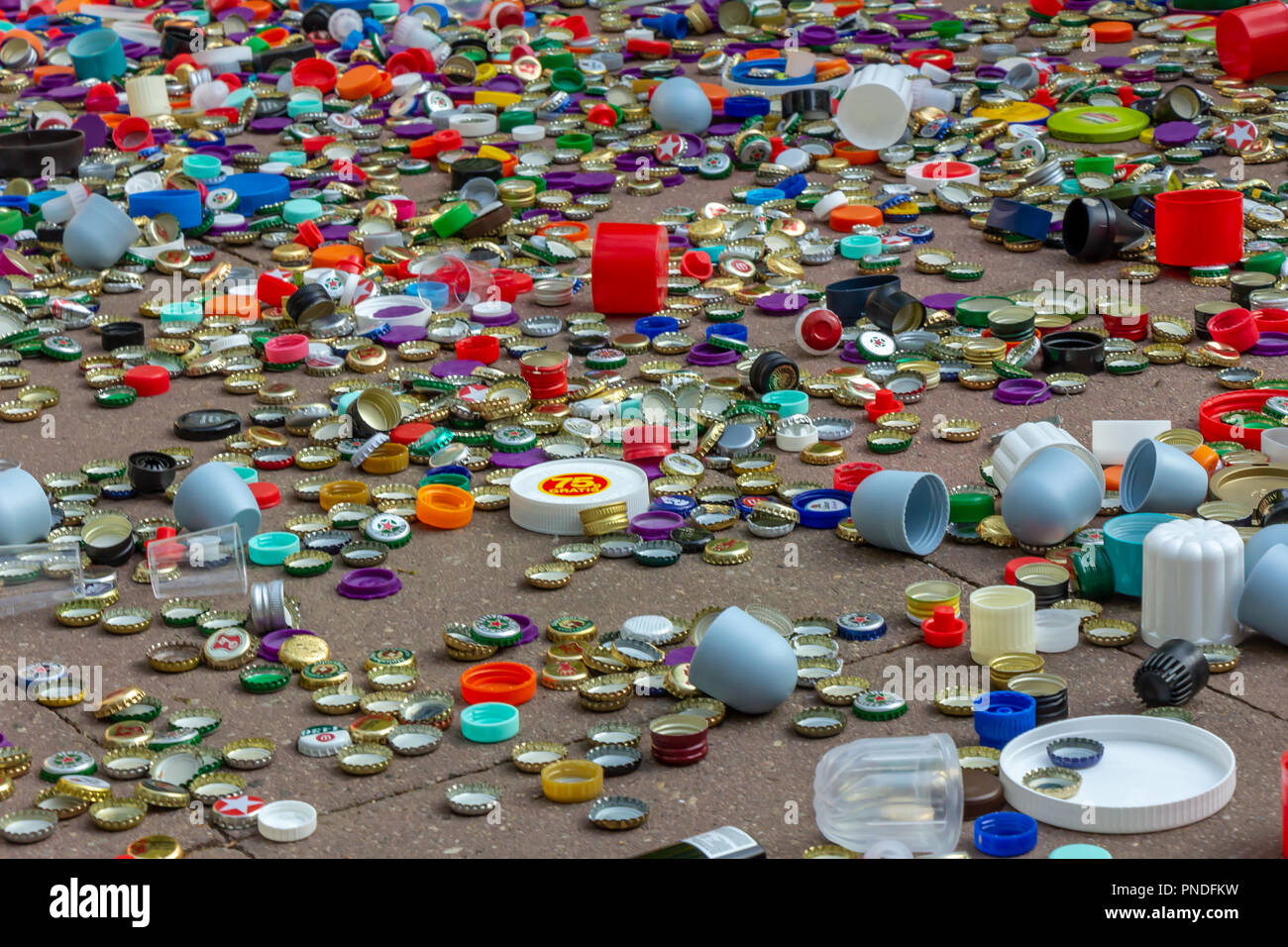 Berlin, Allemagne, 12.05.2018, des milliers de bouchons en plastique en métal doré, rouge, vert, bleu, blanc, argent, etc. éparpillés sur la chaussée. Le recyclage, l'envir Banque D'Images