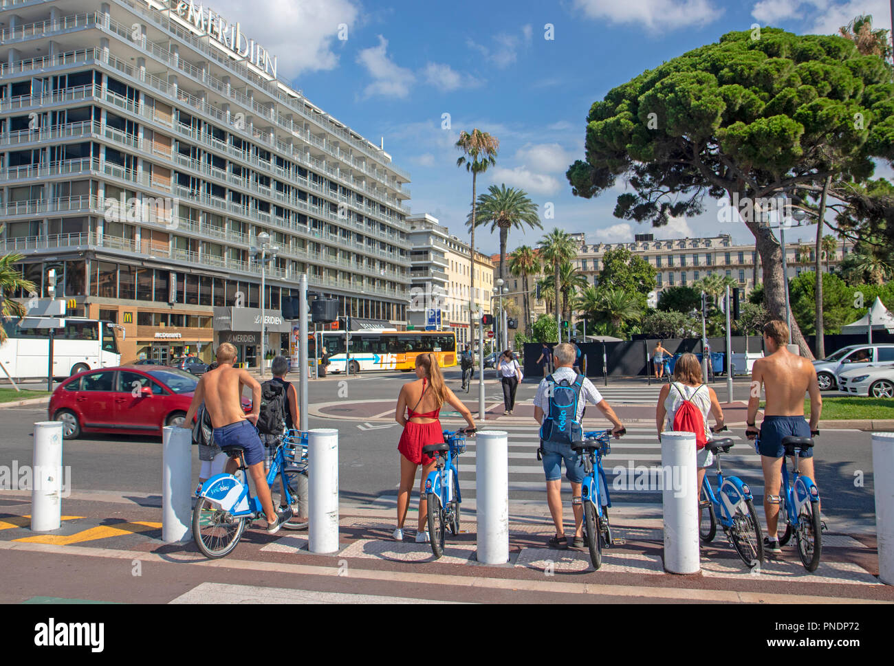 Les cyclistes à l'aide de la part de vélo Nice scheme en attente de traverser la route Banque D'Images