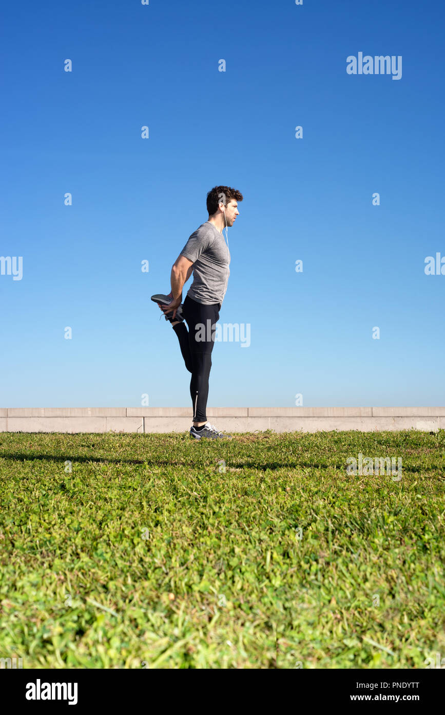 L'homme s'étend la jambe avant l'exécution de l'espace pour le texte Banque D'Images