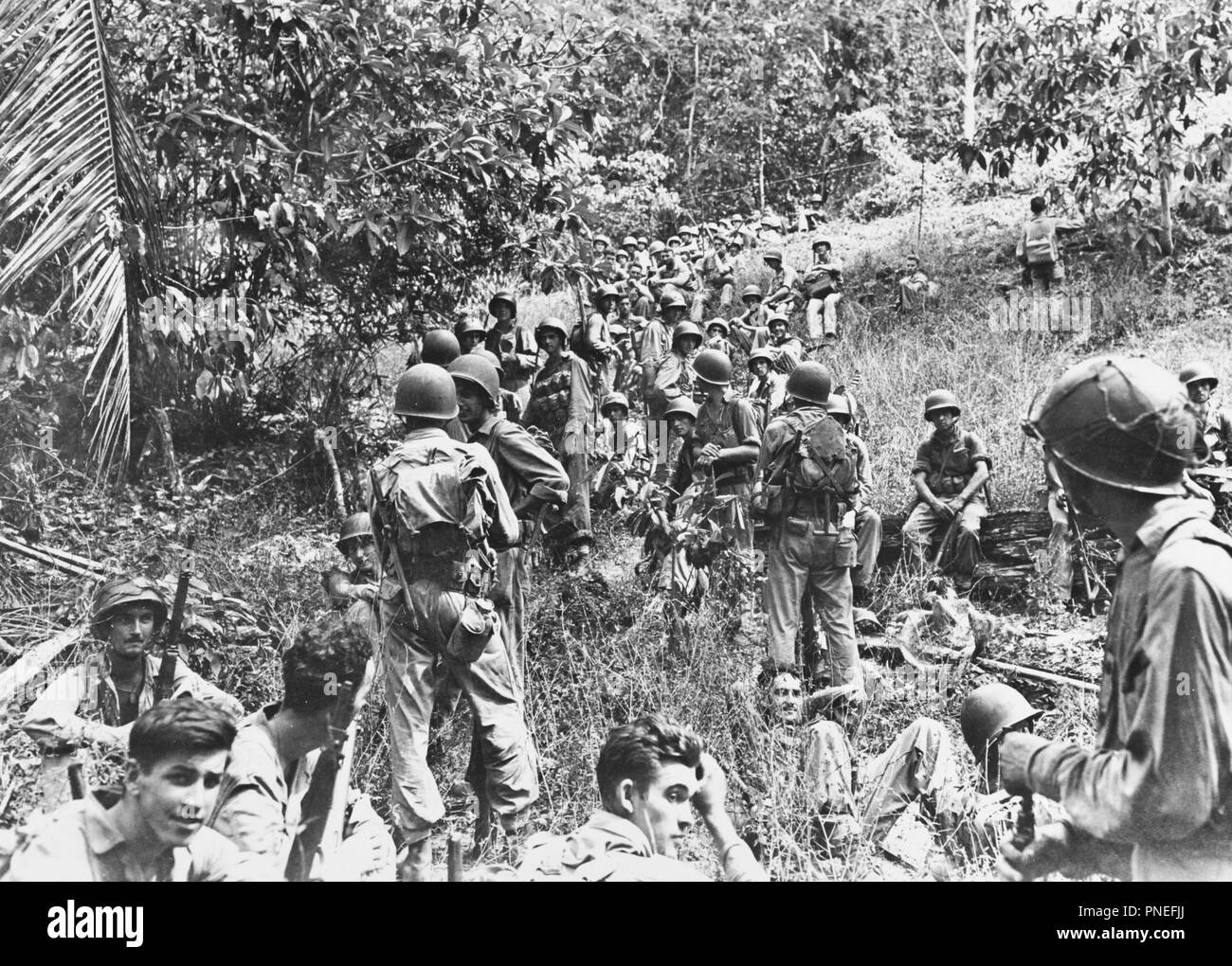 La campagne de Guadalcanal, Août 1942 Février 1943 US Marines reste dans le domaine sur Guadalcanal, vers août-décembre 1942. La plupart de ces marines sont armés de M1903 vis-action rifles et transporter M1905 de baïonnettes et de l'USMC 1941 pochettes. Deux hommes haut sur la colline à droite porter des gilets et de mortier dans un centre a une guerre mondiale I type veste grenade. Le milieu marin assis à l'extrême droite a un fusil automatique Browning. Banque D'Images