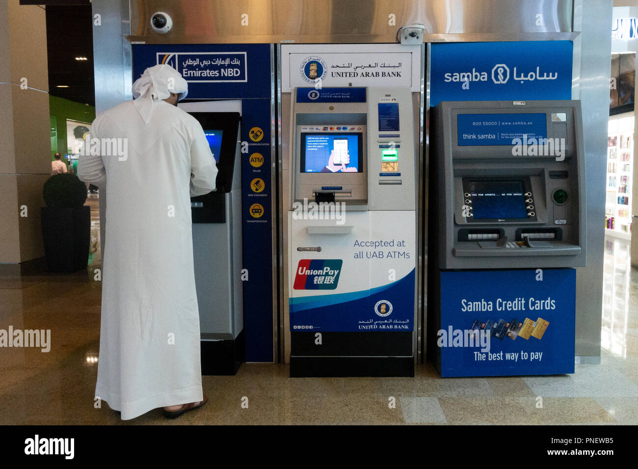 L'homme à l'aide d'espèces Emirati ATM machine à DUBAÏ, ÉMIRATS ARABES UNIS Banque D'Images