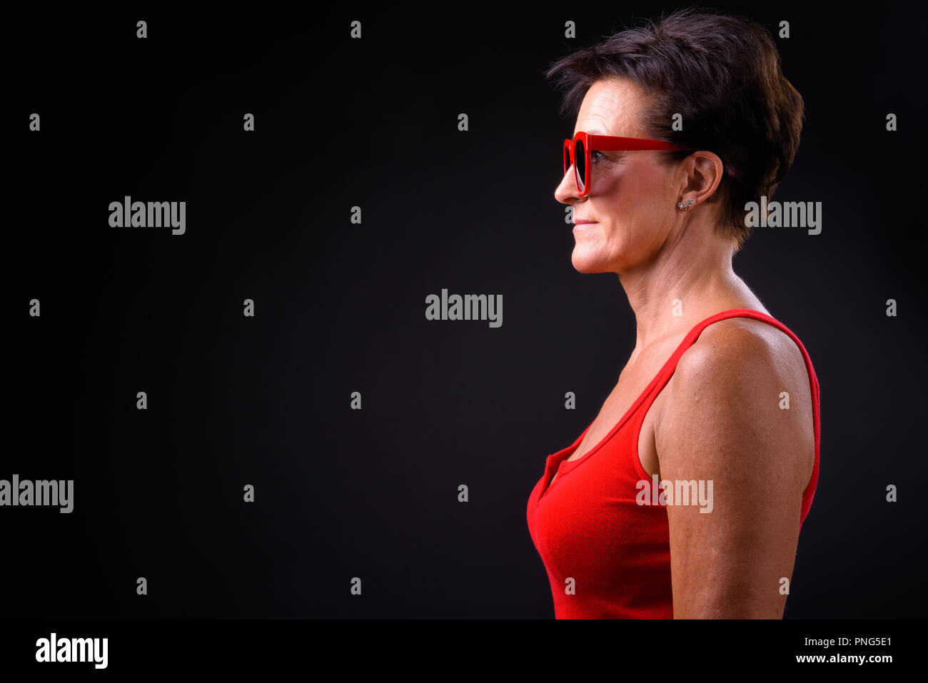 Belle femme mature aux cheveux courts sur fond noir Banque D'Images