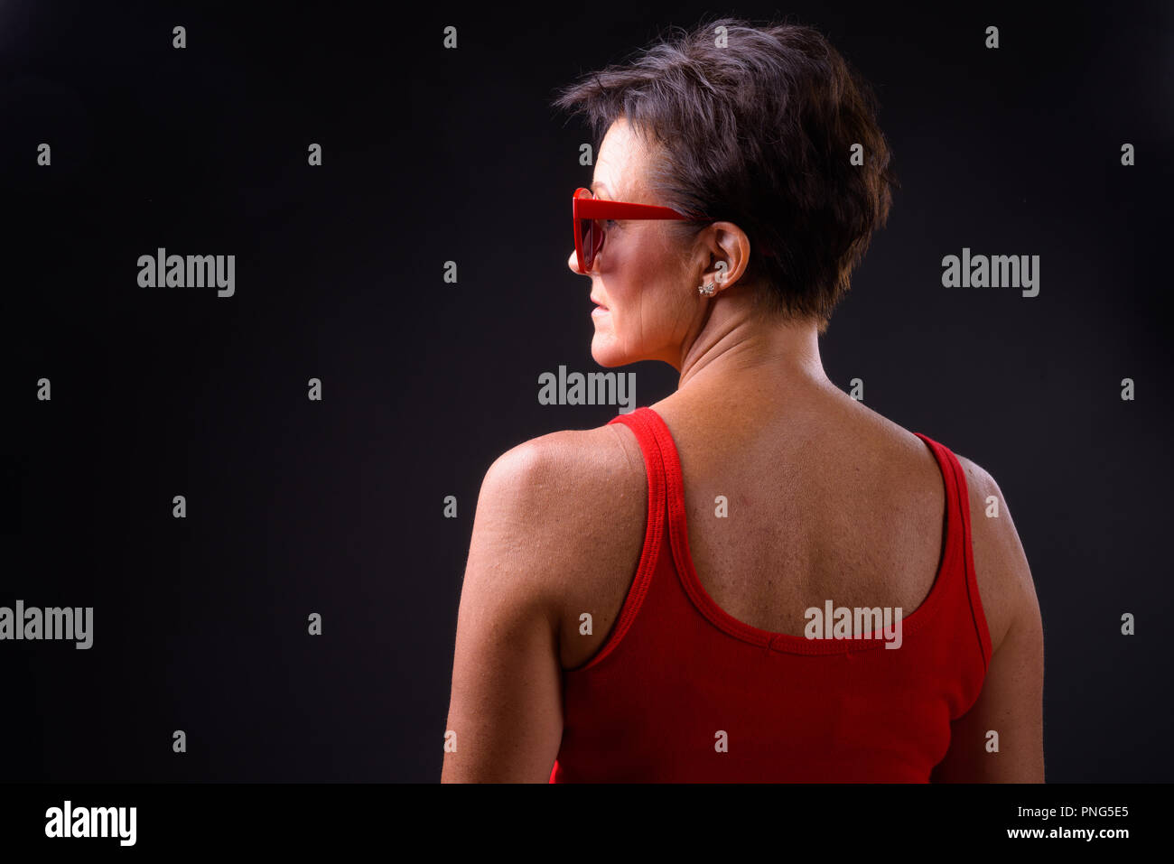 Belle femme mature aux cheveux courts sur fond noir Banque D'Images