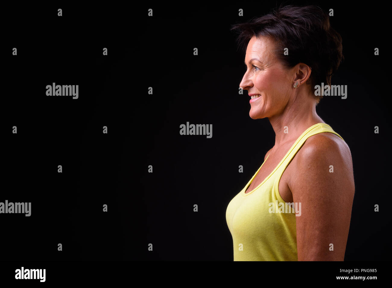 Belle femme mature aux cheveux courts sur fond noir Banque D'Images