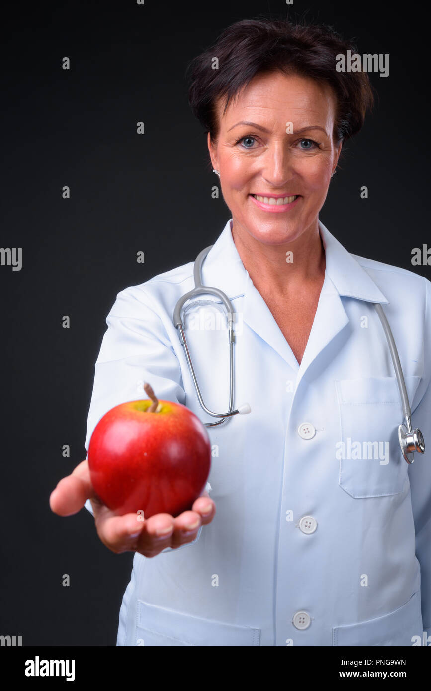Belle mature femme médecin aux cheveux courts à l'arrière noir Banque D'Images Belle mature femme médecin aux cheveux courts à l'arrière noir Banque D'Images