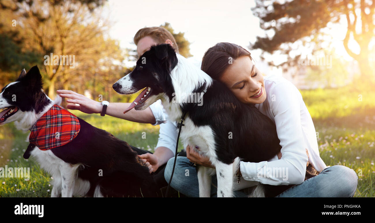 Belle brune jouant avec chien dans la nature pendant le coucher du soleil Banque D'Images