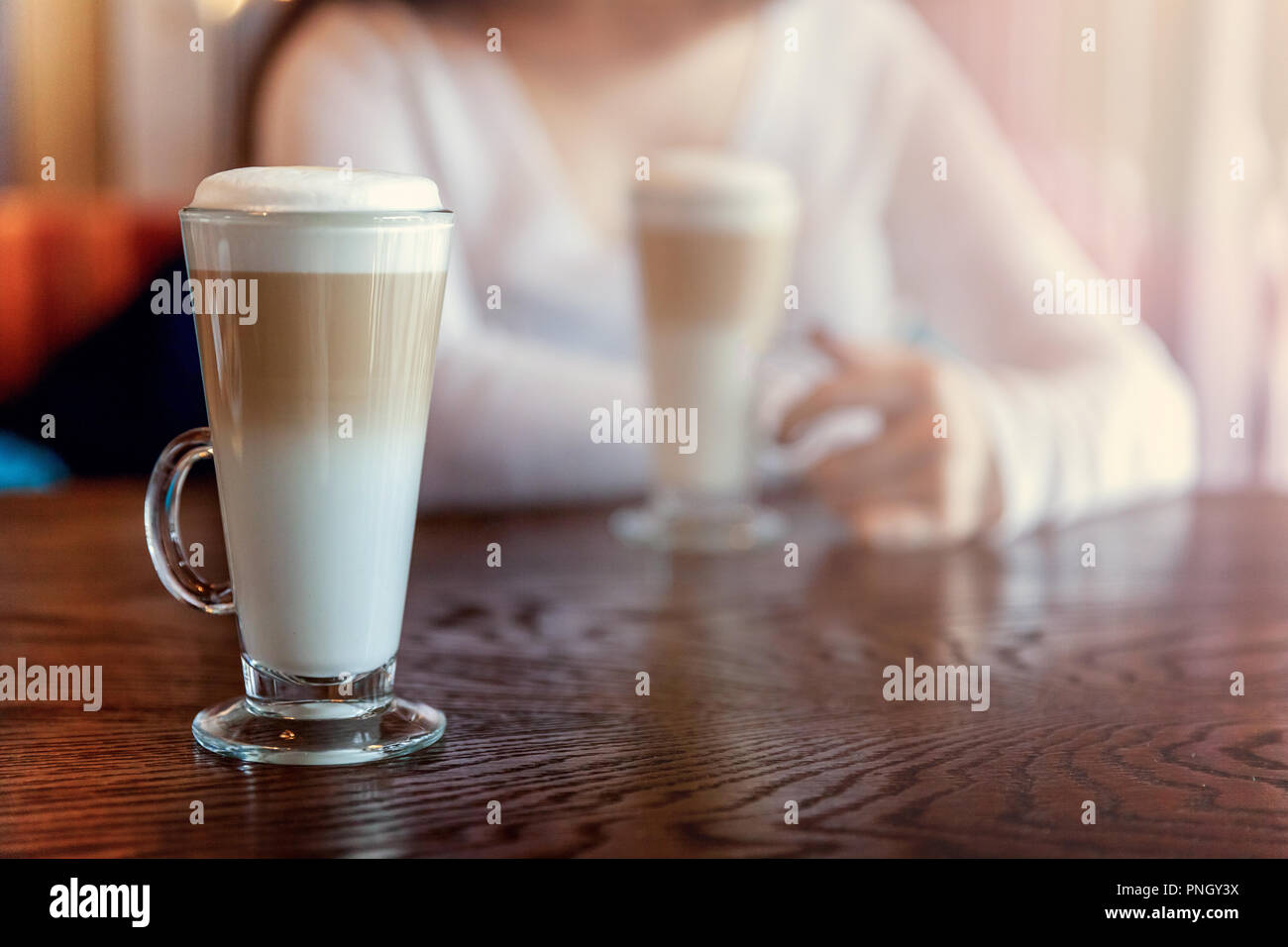 Latte macchiato boisson au verre grand close up. Cappuccino crème fraîche sur la table dans le café. Service de réveil matin, concept de la toxicomanie Banque D'Images