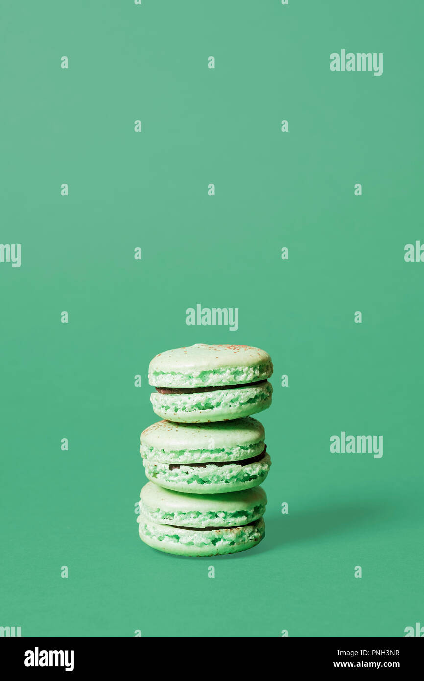 Trois macarons menthe verte sur fond vert avec espace pour copier et texte Banque D'Images
