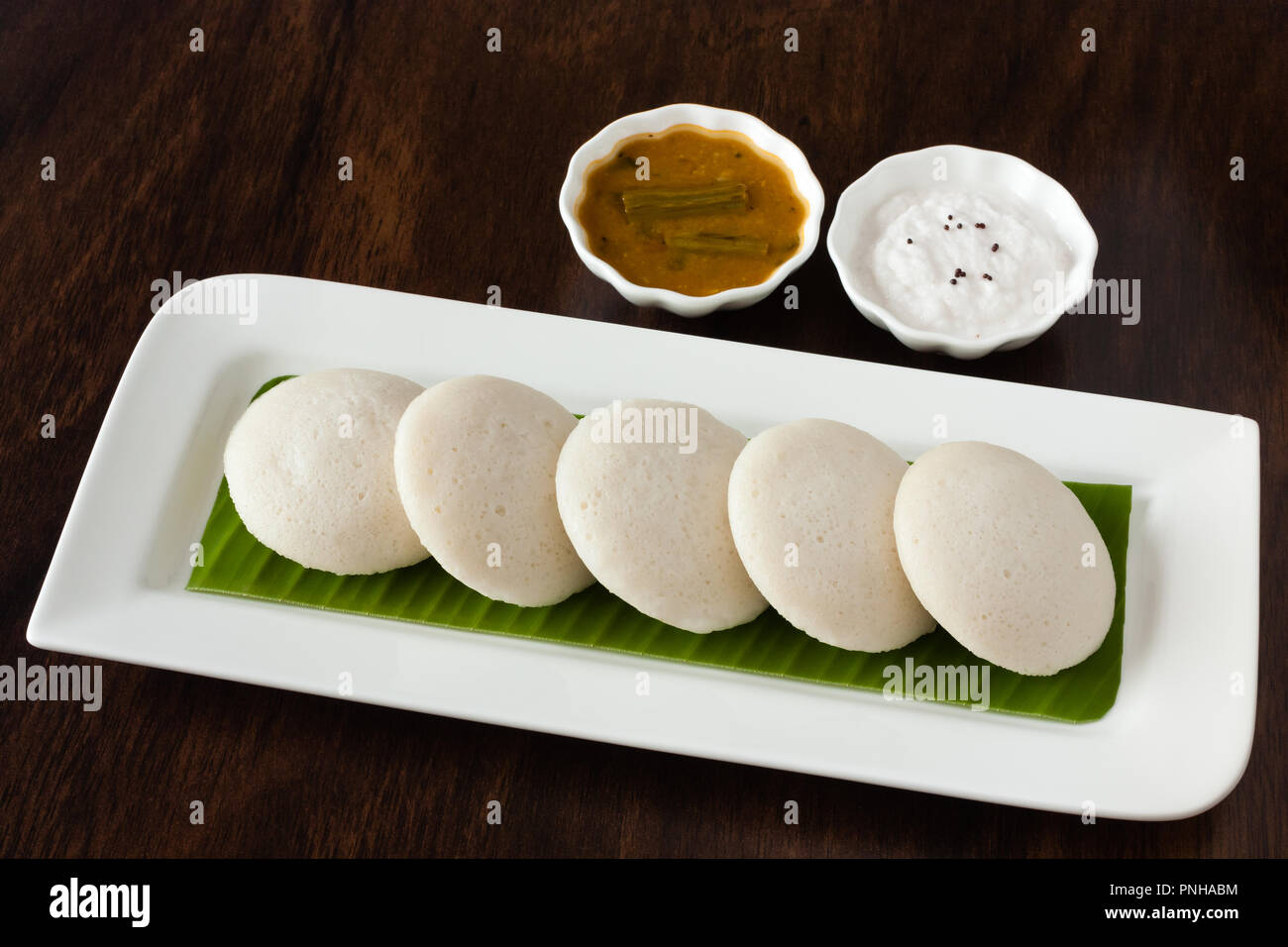 Les Indiens A La Vapeur Douce Sans Rien Faire Idli Gateau De Riz Disposes Sur Une Assiette Couverte D Une Feuille De Bananier Servi Avec Un Chutney De Noix De Coco Et Les Indiens A La Vapeur Douce Sans Rien Faire Idli Gateau De Riz Disposes Sur Une Assiette Couverte D Une Feuille De Bananier Servi Avec Un Chutney De Noix De Coco Et