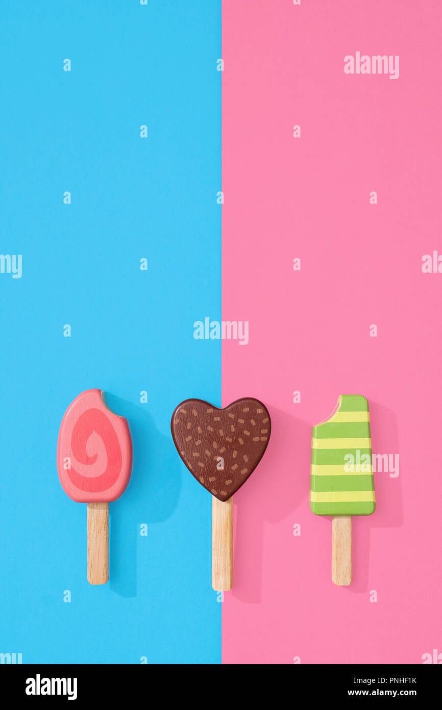 Jouet en bois assorties sucette sucettes de glace sur une rose pastel et de  couleur bleu avec de l'espace pour copier et texte Photo Stock - Alamy