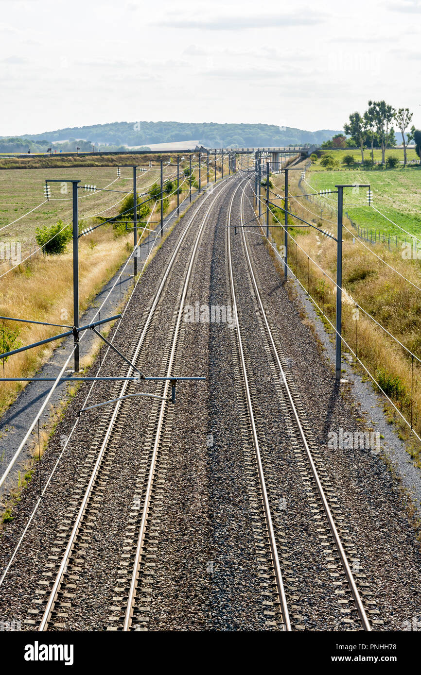 Vue de dessus d'une voie ferroviaire à grande vitesse français avec l'équipement de lignes aériennes faites de poteaux, caténaires, câbles et lignes électriques pour alimenter les trains. Banque D'Images