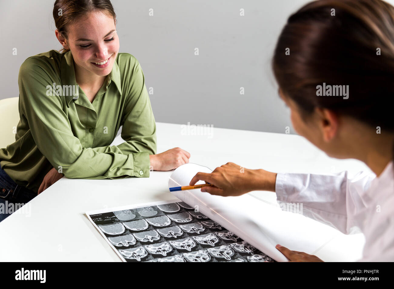 Patient smiling over CT scan looking at X-ray. Plan moyen. Banque D'Images