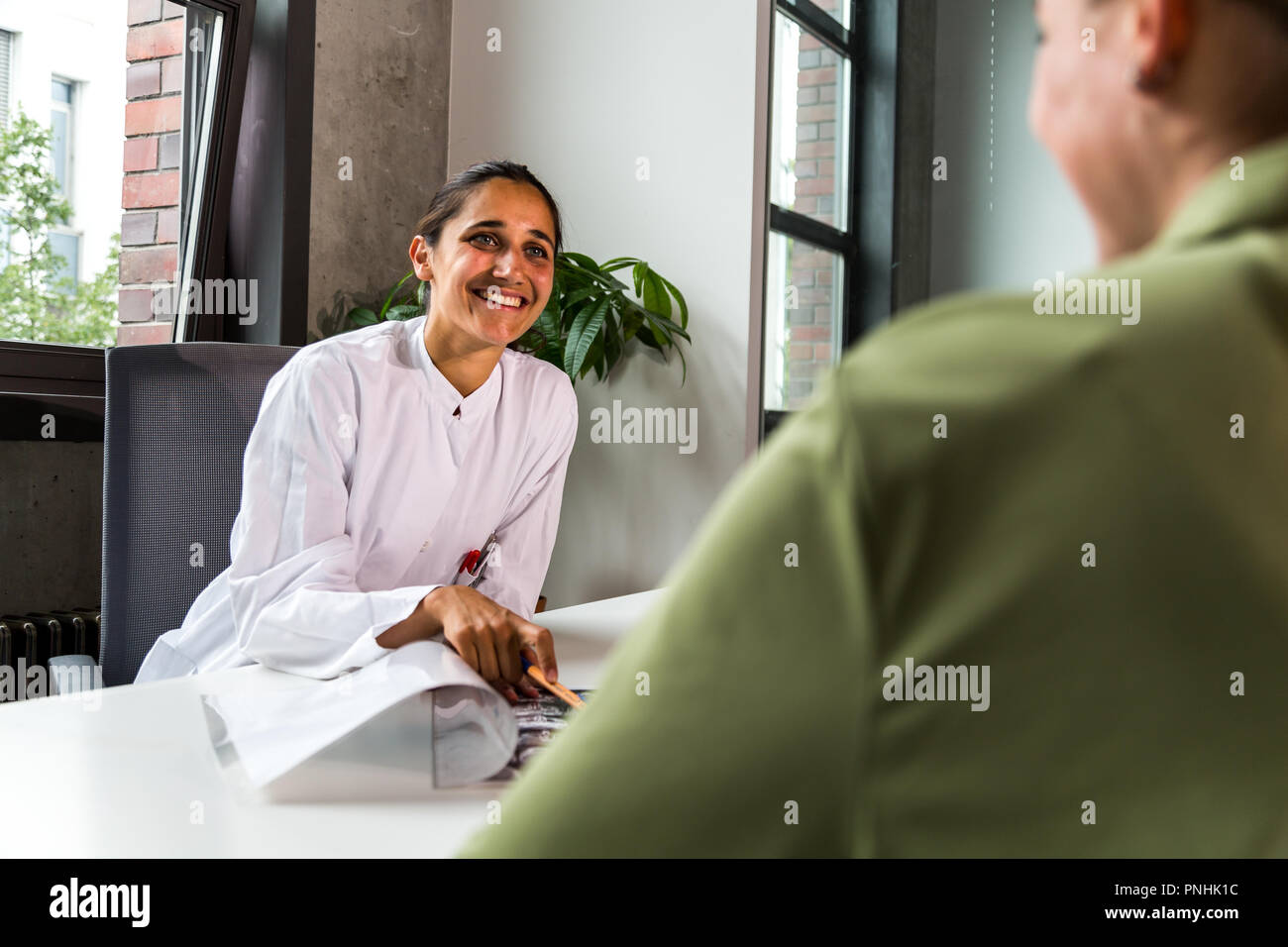 Female doctor smiling plus d'un scanner CT avec un patient. Plan moyen. Banque D'Images