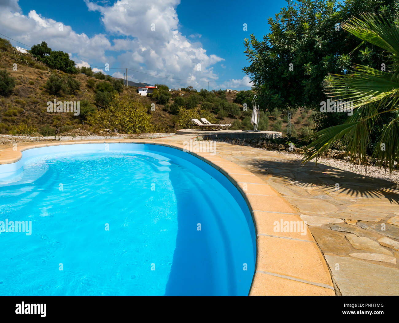 Petite piscine en forme de rein surplombant la vallée de la montagne près de Canillas de Acietuna, Axarquía, Andalousie, Espagne Banque D'Images