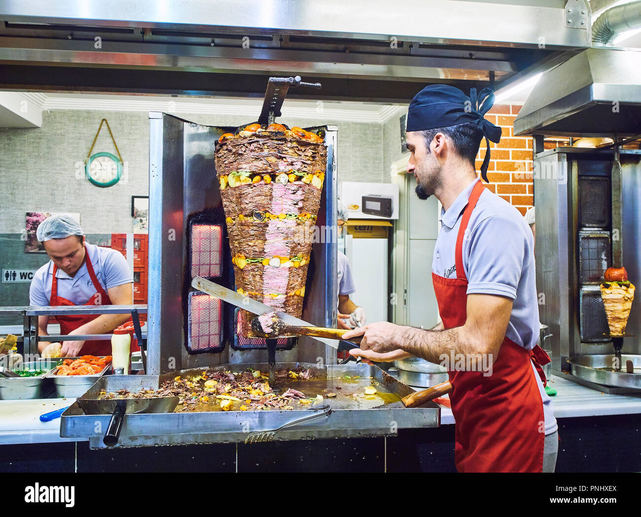 Bodrum, Turquie - le 5 juillet 2018. Un cuisinier couper la viande et légumes tranches d'un Doner kebab turc traditionnel dans une stalle de rue. Banque D'Images
