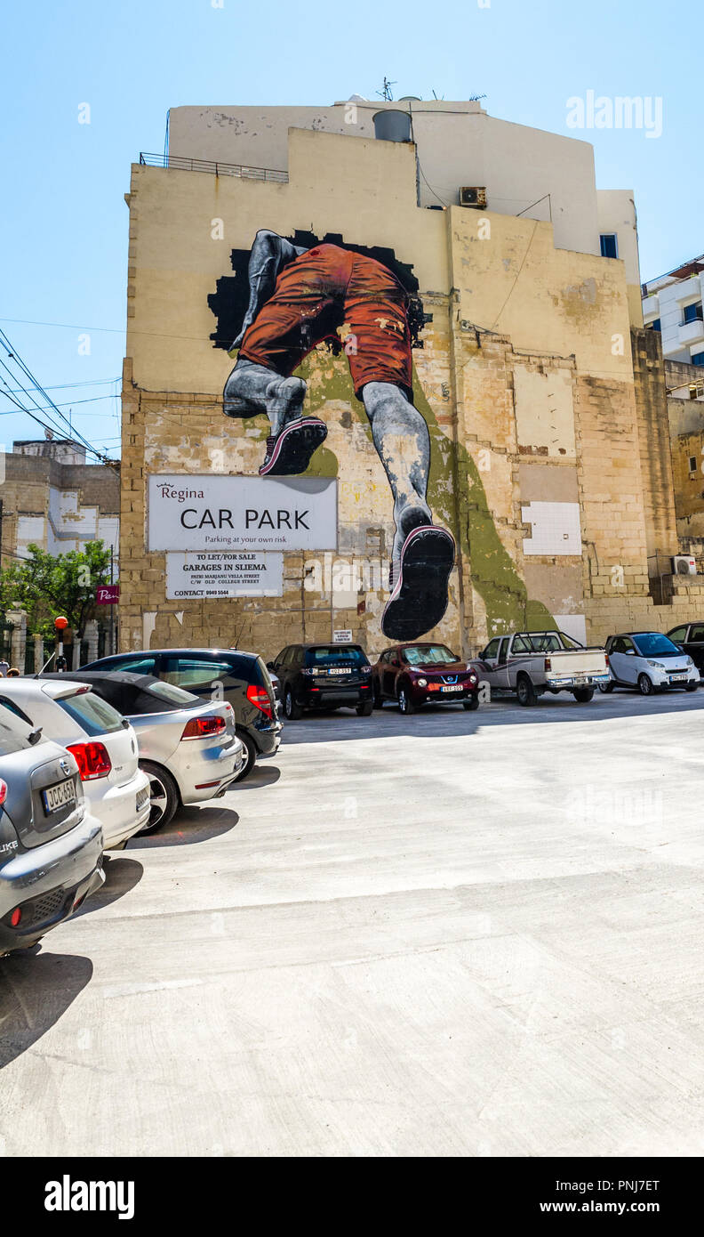 Grande peinture murale d'une personne randonnées à travers un trou dans un parking. Banque D'Images Grande peinture murale d'une personne randonnées à travers un trou dans un parking. Banque D'Images