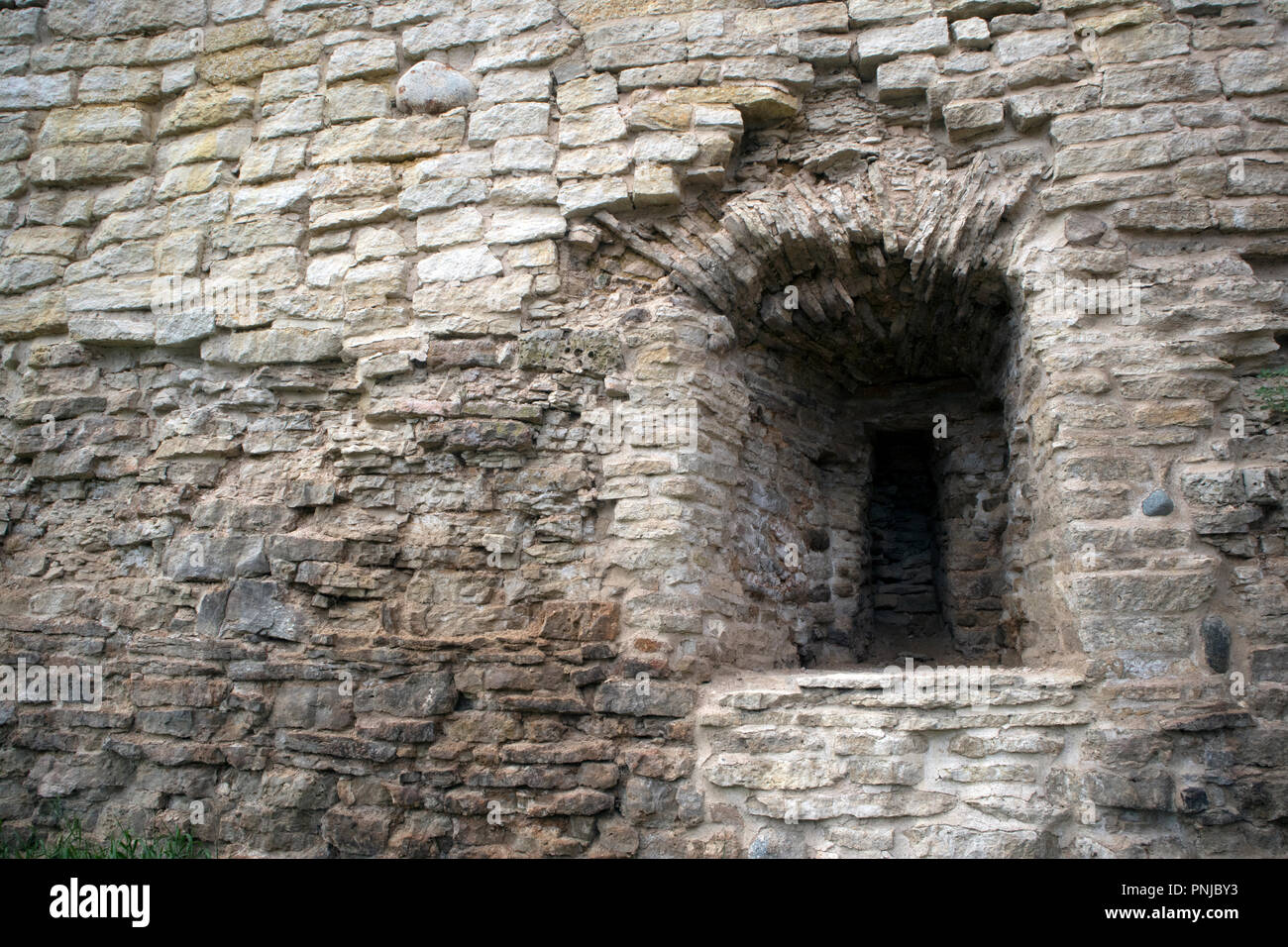 Maçonnerie antique, fragment de l'ancienne muraille de calcaire en ruine avec meurtrière Banque D'Images