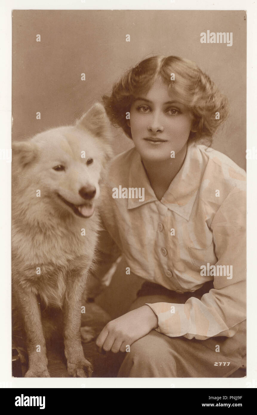 Original début 1900's teinté couleur sépia carte postale de la belle jeune actrice Peggy Kurton avec un chien Samoyed, vers 1916, Royaume-Uni Banque D'Images
