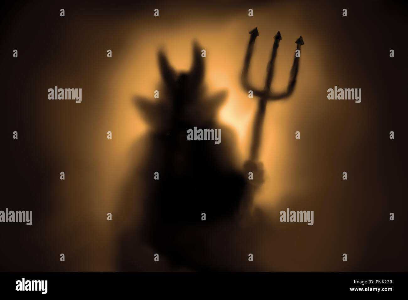 Devil Creepy silhouette derrière un verre gelé et dans la brume avec l'afficheur. Banque D'Images