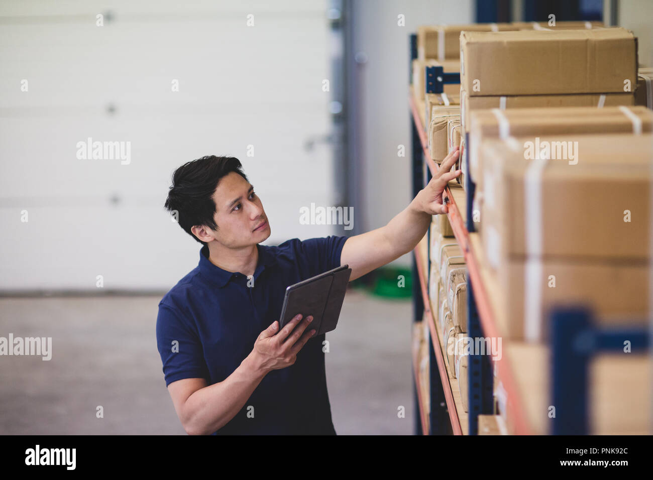 Homme travaillant dans l'entrepôt de distribution with digital tablet Banque D'Images