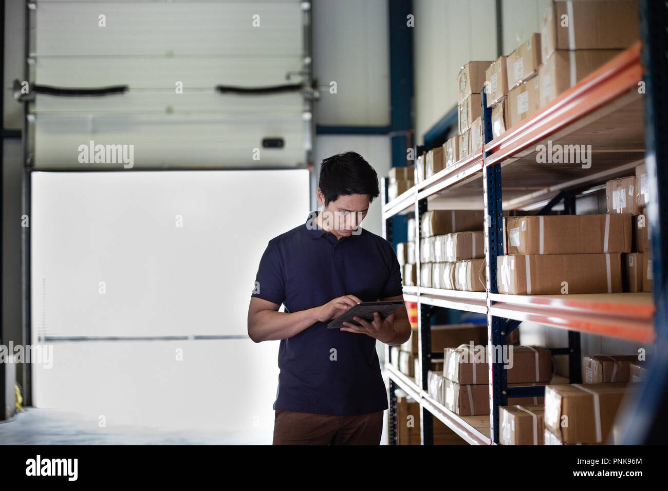 Homme travaillant dans l'entrepôt de distribution with digital tablet Banque D'Images