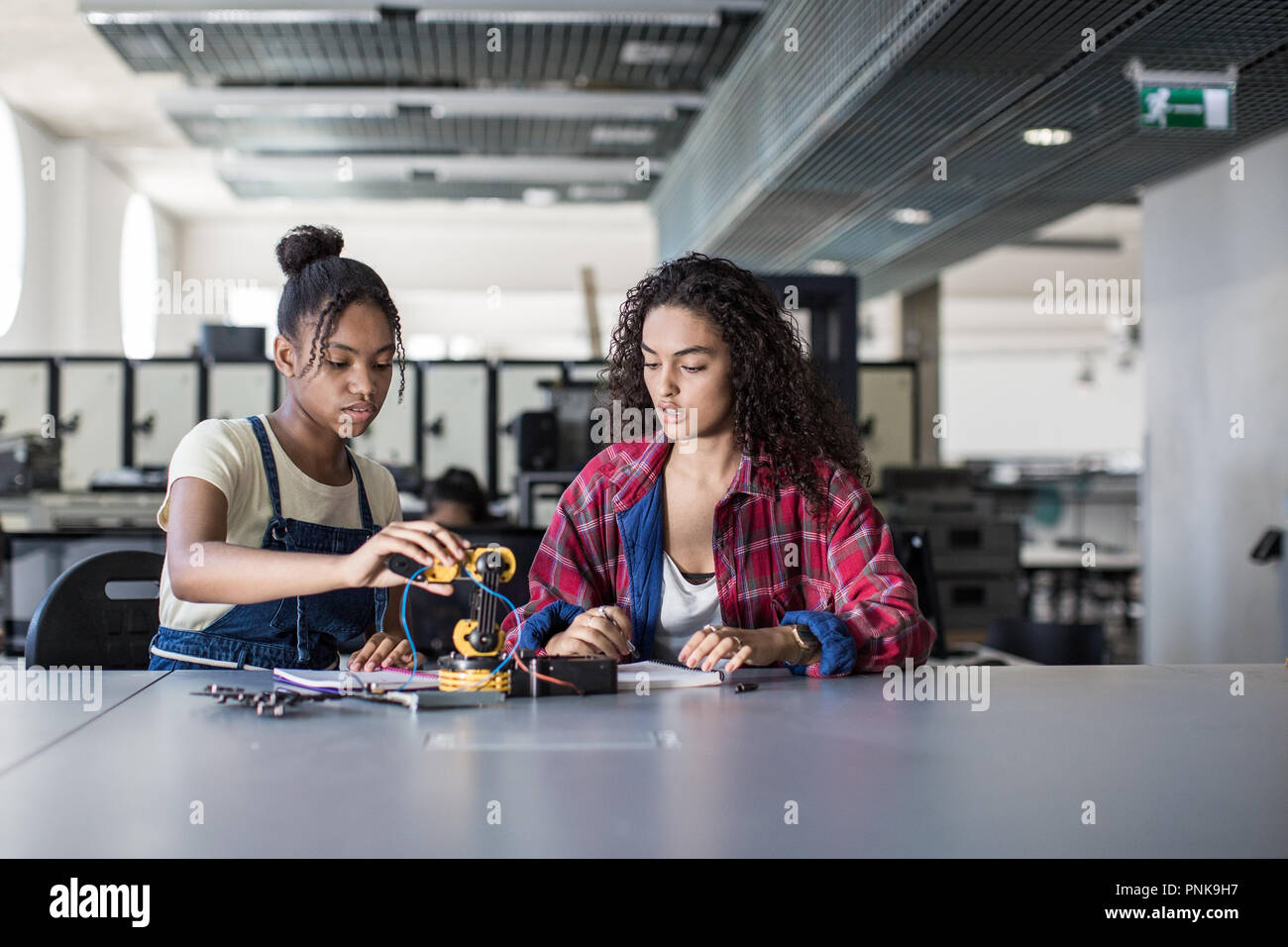 Les élèves du secondaire travaillent sur un bras robotique en classe Banque D'Images